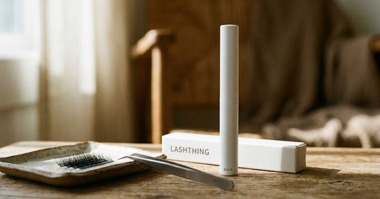 Lashthing bond pen met cluster wimpers en pincet op een houten tafel